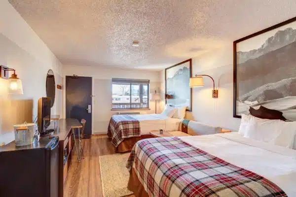 Room with two queen beds and art above