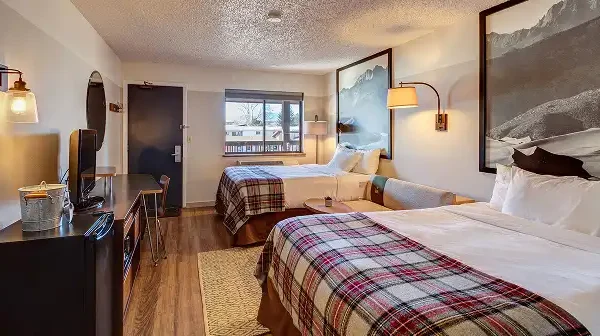 Room with two queen beds and art above